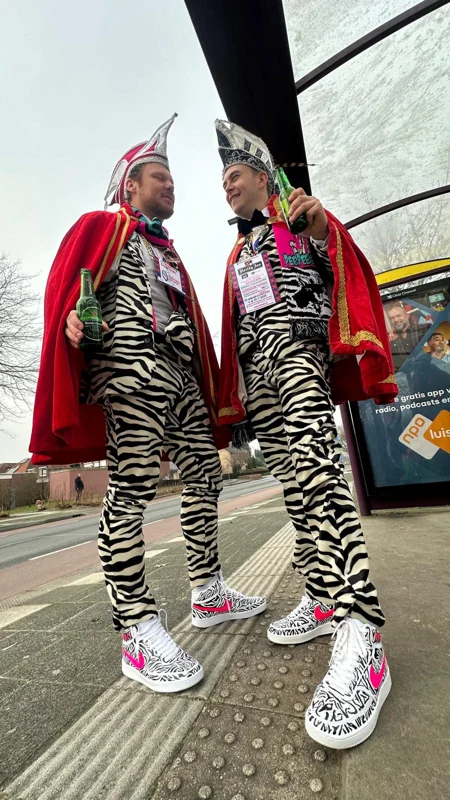 Twee PPEM-leden in zebrapakken en kleurrijke jassen